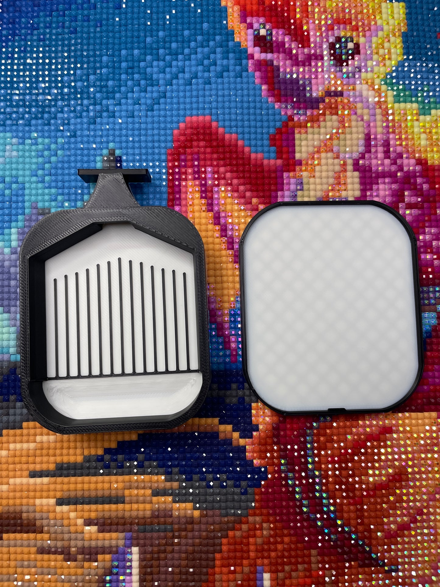 Deluxe 2 Phoenix Small Diamond Painting Tray in black with white belly, shown on colorful diamond painting background.