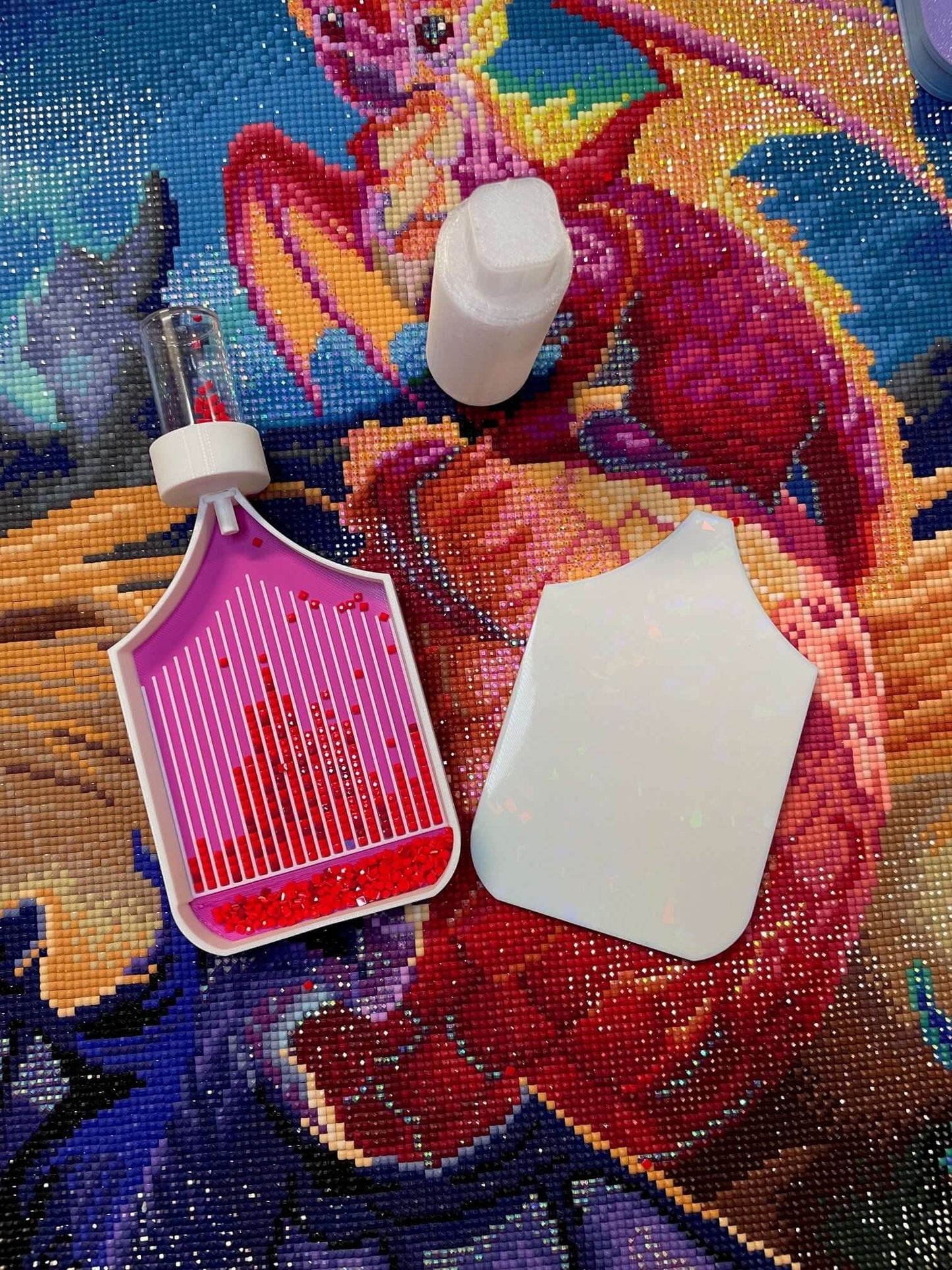 Dragonling Screw & Shake Diamond Art Tray with attached drill container on colorful dragon tapestry background.