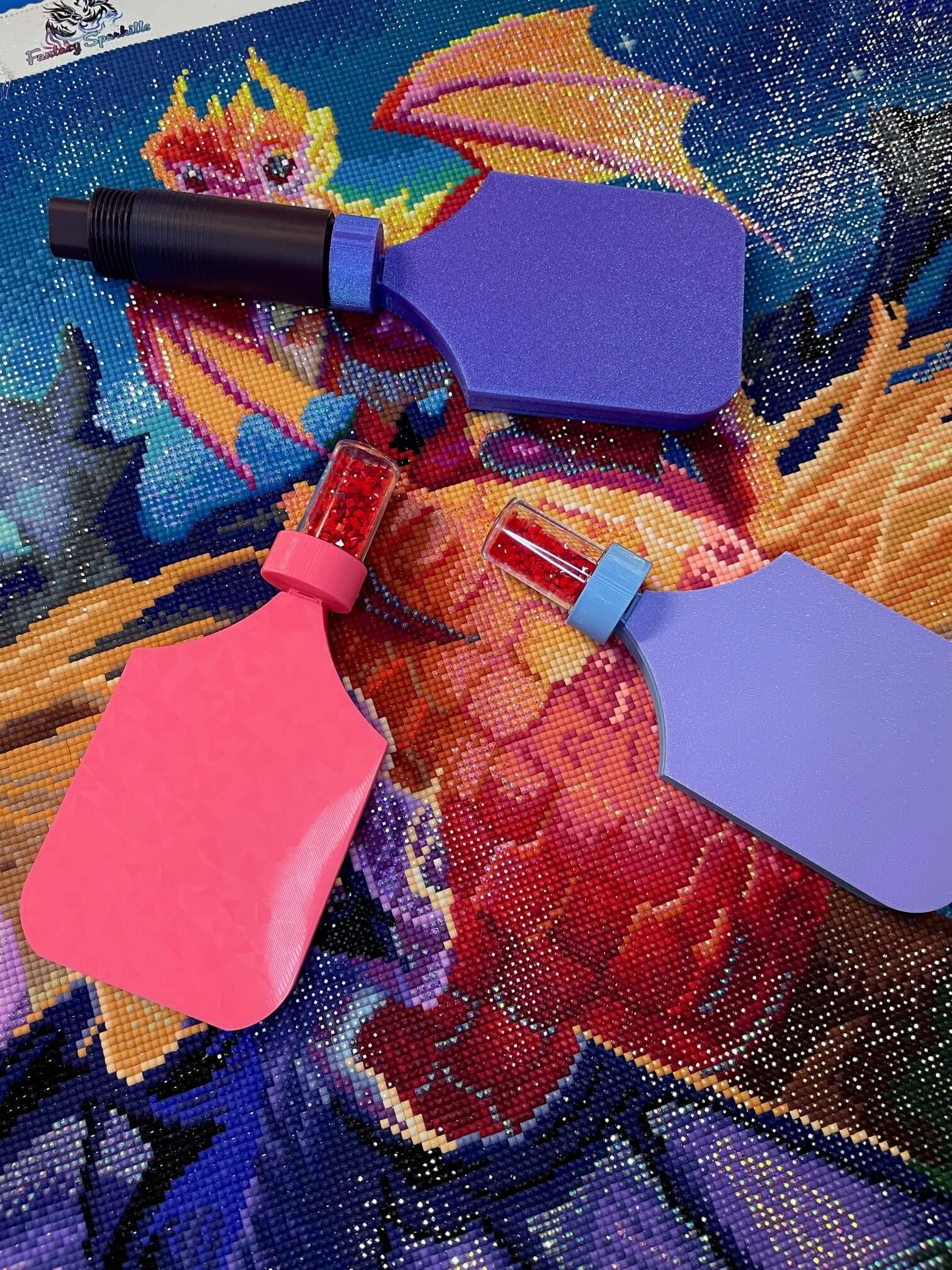 Three Dragonling Screw & Shake diamond art trays with colorful design on a vibrant dragon-themed canvas background.