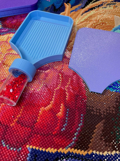Blue Dragonling Screw & Shake diamond art tray with attached container and purple tray lid on colorful diamond art canvas.