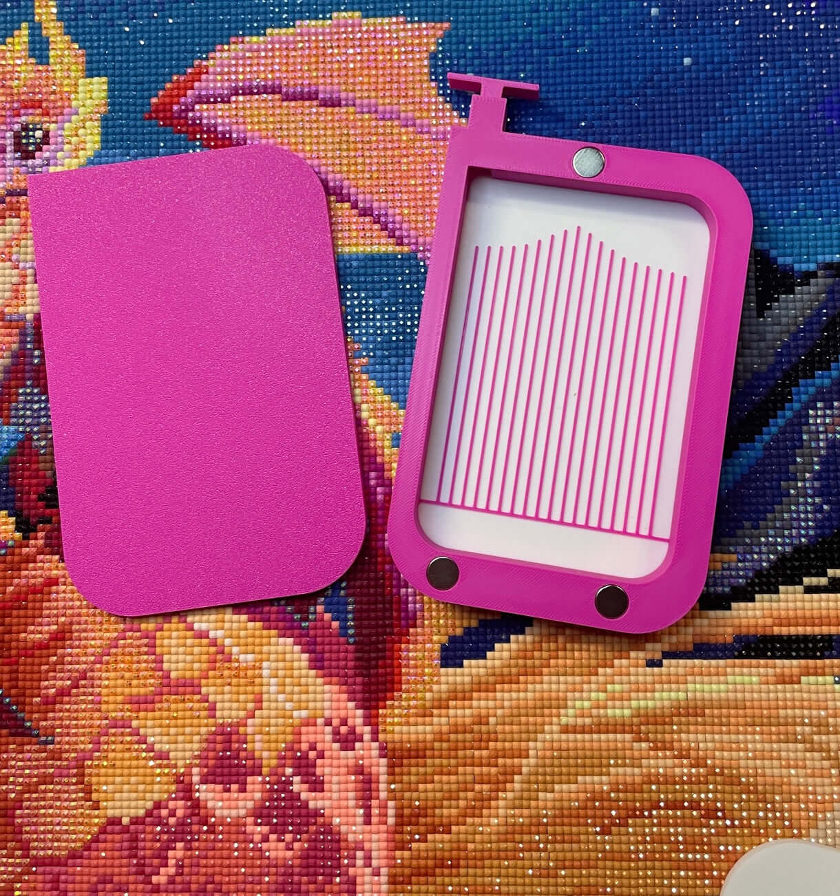 Pink Magnetsaurus diamond art tray with magnetic lid and stopper on a colorful diamond painting background.